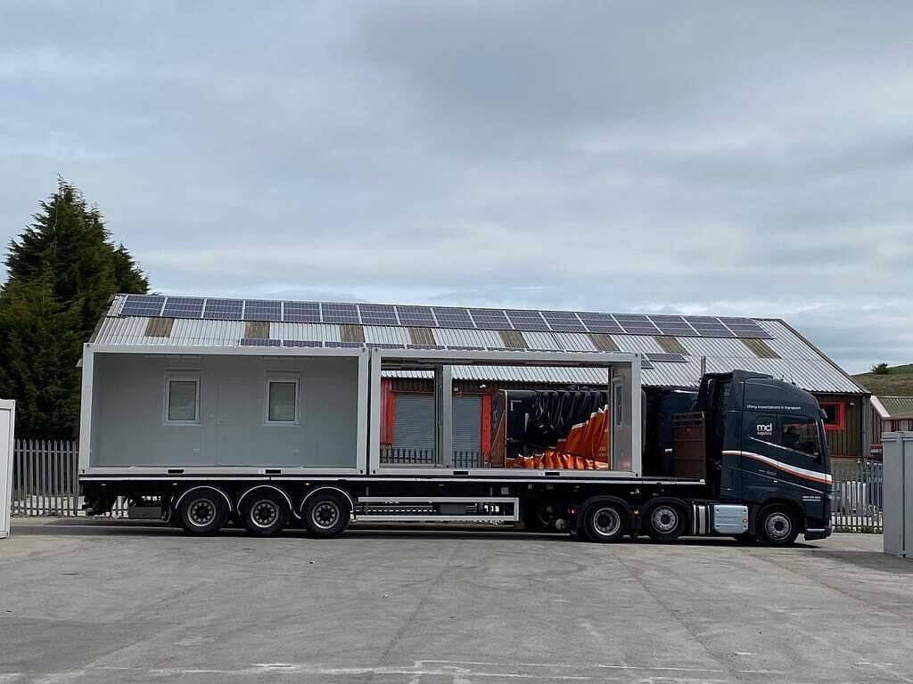 Modular unit with solar panels on a flatbed trailer, ready for delivery